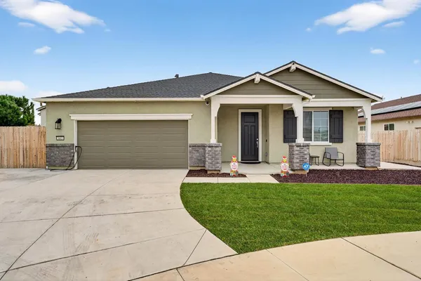 a front view of a house with a yard and patio