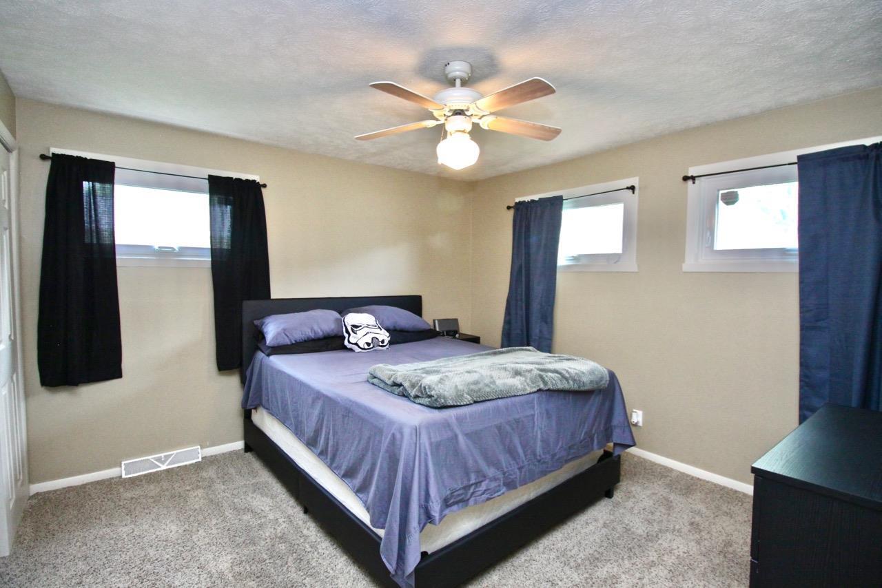4613 Cayuga Road Rockford, IL 61107 - Photo 11 of 19 a bedroom with a bed and a chandelier
