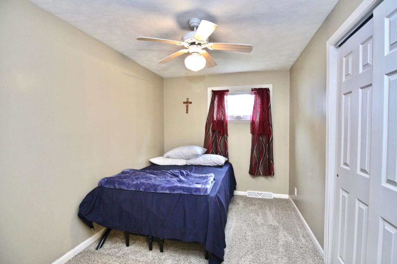 4613 Cayuga Road Rockford, IL 61107 - Photo 12 of 19 a bedroom with a bed and a chandelier