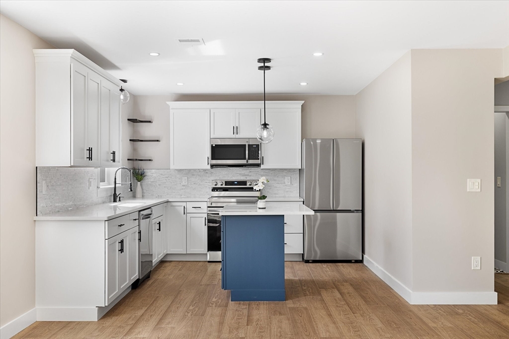 8 Wilson Street Spencer, MA 01562 - Photo 11 of 41 a kitchen with stainless steel appliances granite countertop a refrigerator a stove top oven a sink and dishwasher with wooden floor