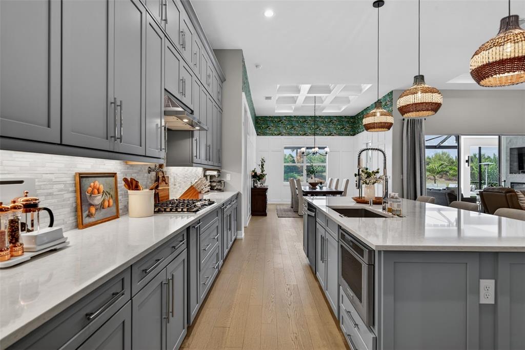 8331 Redonda Loop Lakewood Ranch, FL 34202 - Photo 16 of 92 a kitchen with stainless steel appliances granite countertop a sink a stove and a wooden floors