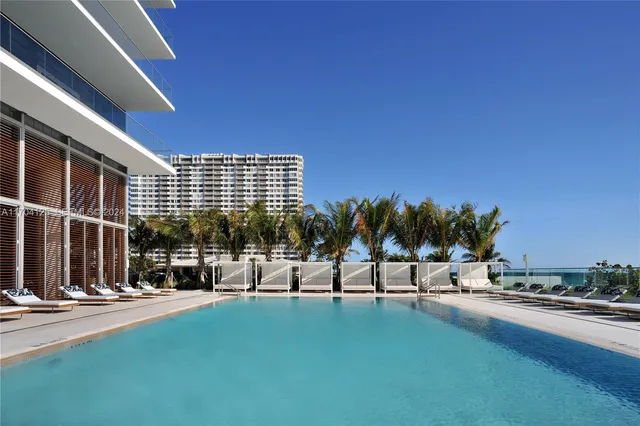 a view of swimming pool with outdoor seating and a glass door