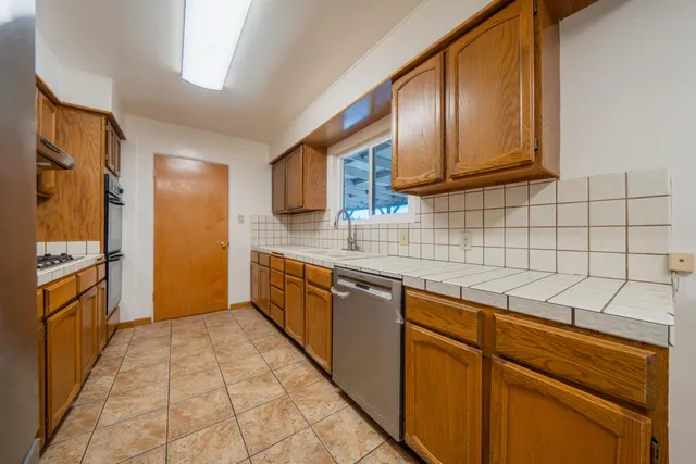 a kitchen with stainless steel appliances granite countertop a sink stove and cabinets