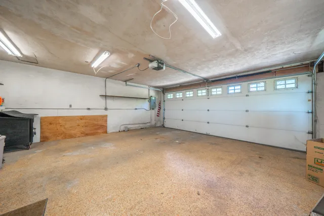 a view of a backyard with wooden fence and a large tree