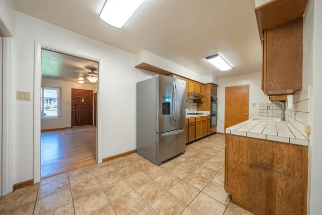 a kitchen with stainless steel appliances granite countertop a refrigerator and a sink