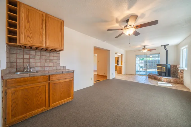 a view of an empty room with a window and a kitchen
