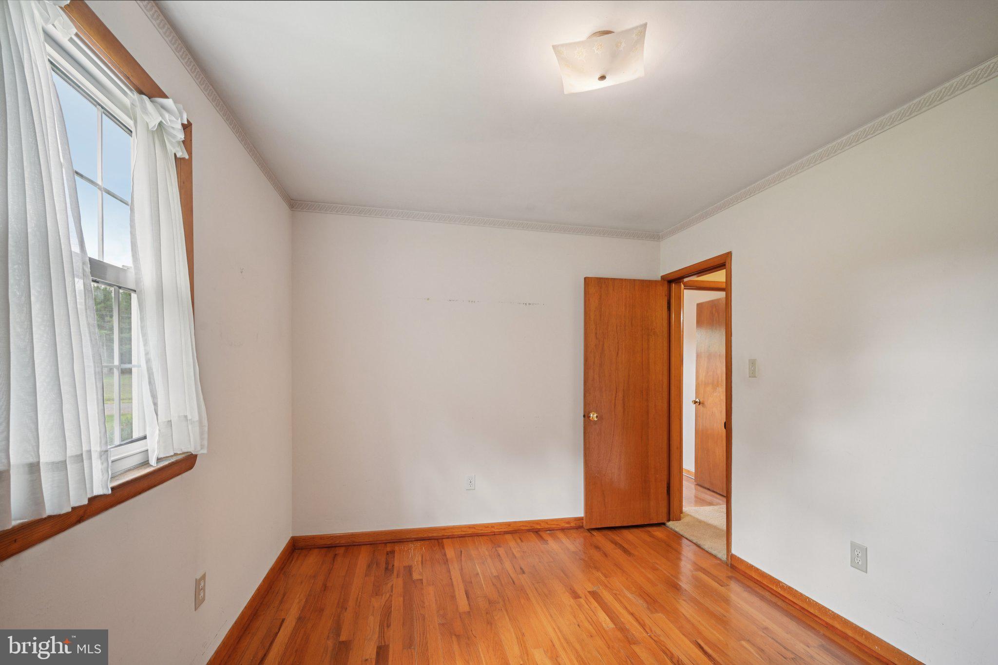 9 Cooper Tomlinson Road Medford, NJ 08055 - Photo 28 of 39 a view of an empty room with wooden floor and a window