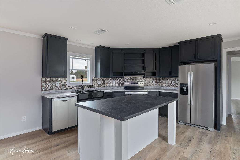 607 Nettleton Drive Princeton, LA 71067 - Photo 4 of 14 a kitchen with stainless steel appliances granite countertop a sink stove microwave and refrigerator