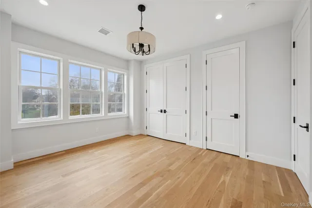 a view of an empty room with a window and a kitchen