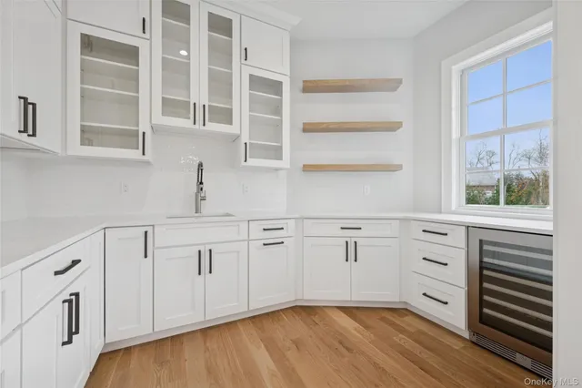 a kitchen with white cabinets and a window