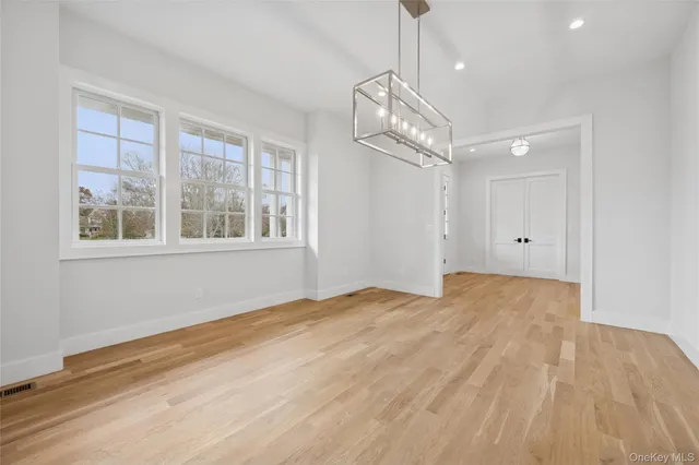 a view of empty room with wooden floor and windows