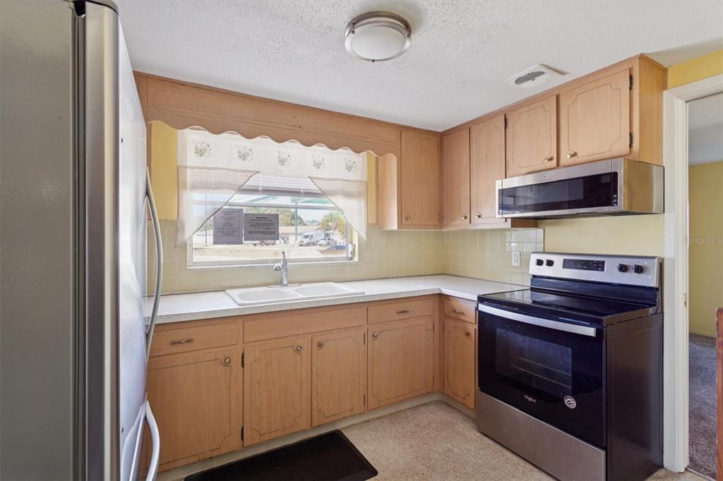 7608 Redcoat Avenue Port Richey, FL 34668 - Photo 10 of 28 a kitchen with a sink stove and microwave