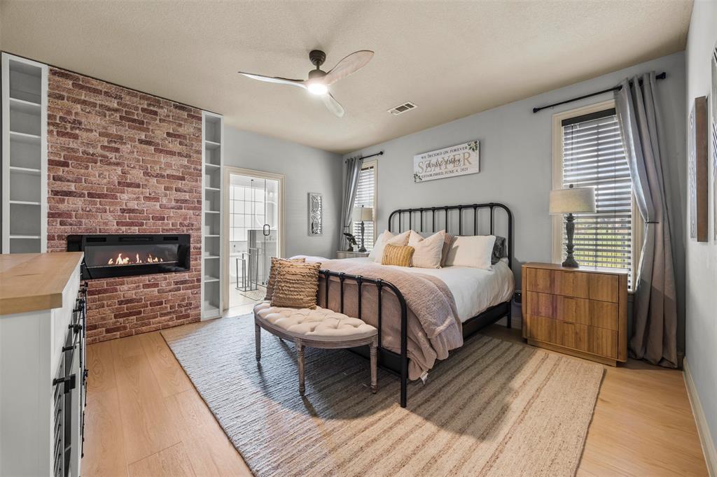 3175 Collins Road Burleson, TX 76028 - Photo 20 of 40 a spacious bedroom with a bed and a fireplace
