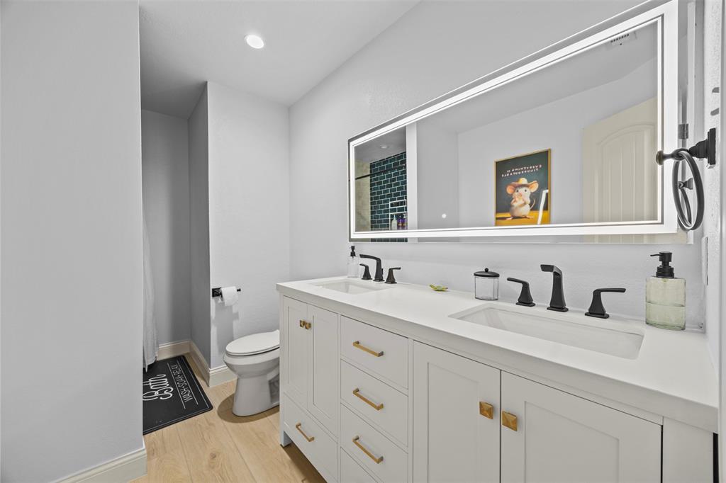 3175 Collins Road Burleson, TX 76028 - Photo 32 of 40 a bathroom with a toilet a sink and mirror