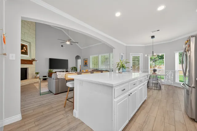 a large white kitchen with a large window a sink and stainless steel appliances