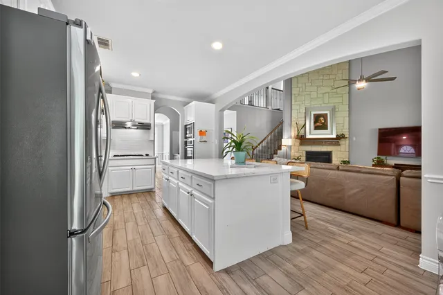 a kitchen with stainless steel appliances a refrigerator and a stove top oven