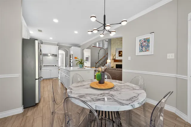 a kitchen with stainless steel appliances granite countertop a dining table and chairs