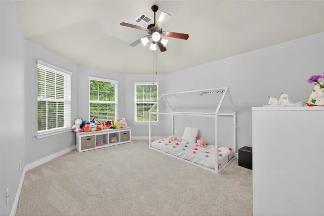 a bedroom with furniture and a chandelier fan