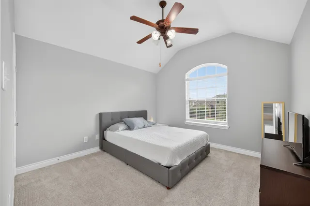 a bedroom with a bed a chandelier and a window