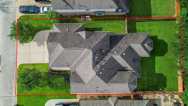 an aerial view of a house with garden space and street view
