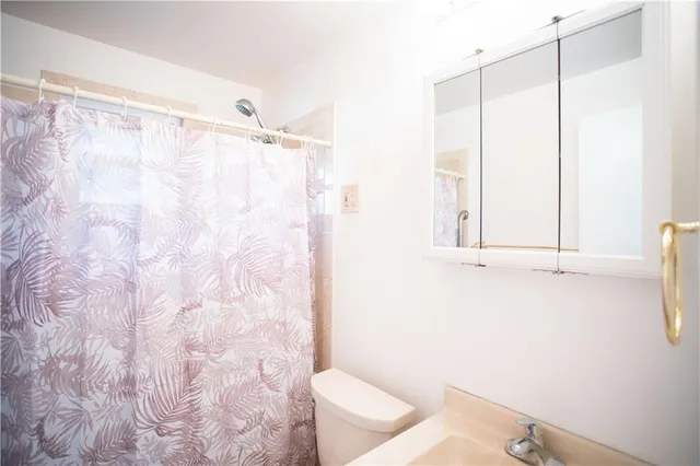 a bathroom with a shower curtain and a sink