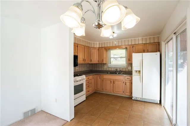 a kitchen with stainless steel appliances granite countertop a stove a sink and a refrigerator