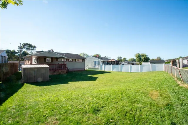 a view of a backyard with barn and wooden fence