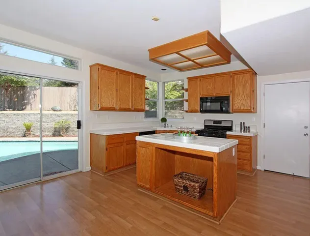 a kitchen with stainless steel appliances granite countertop a stove a sink and a microwave
