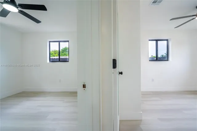 an empty room with windows and cabinet