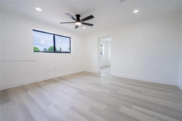 a view of a big room with wooden floor and windows