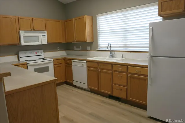 a kitchen with stainless steel appliances granite countertop a sink a stove a refrigerator with grey cabinets