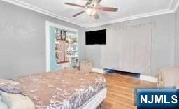 452 Minton Place Orange, NJ 07050 - Photo 13 of 14 a bedroom with a bed and a flat screen tv