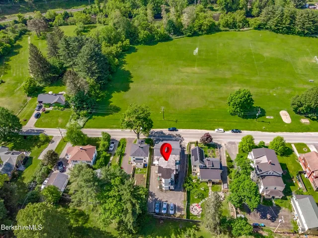 an aerial view of residential houses with outdoor space and swimming pool