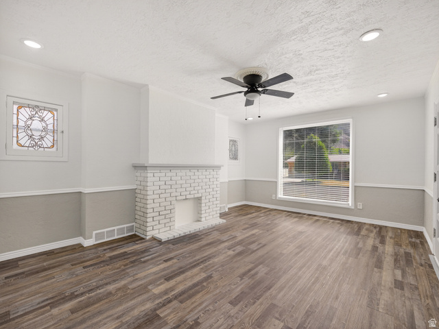 74 South 300 East Springville, UT 84663 - Photo 5 of 48 Spacious living area featuring wood-finish flooring, a white brick fireplace, and a decorative stained glass window