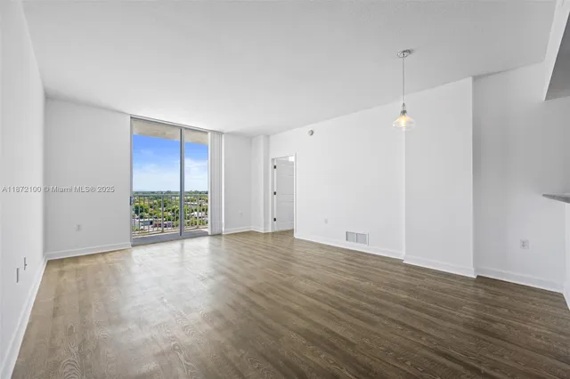 an empty room with wooden floor and window