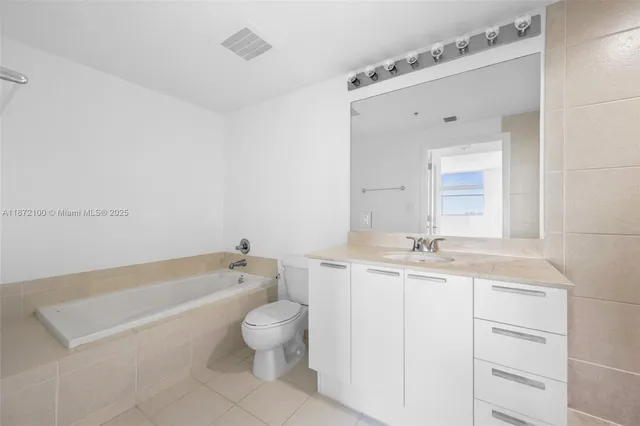 a bathroom with a granite countertop sink a toilet and bathtub
