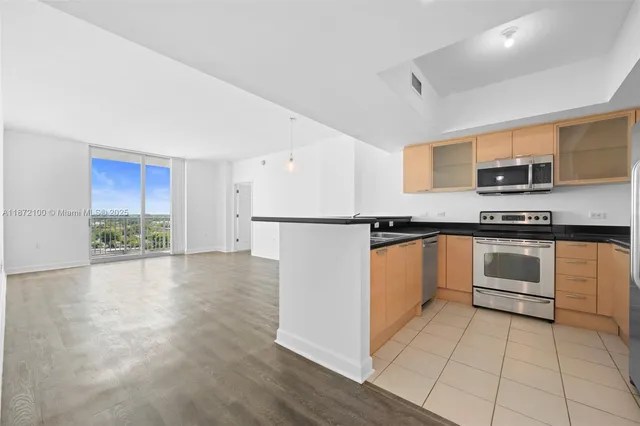 a kitchen with granite countertop a refrigerator and a stove top oven
