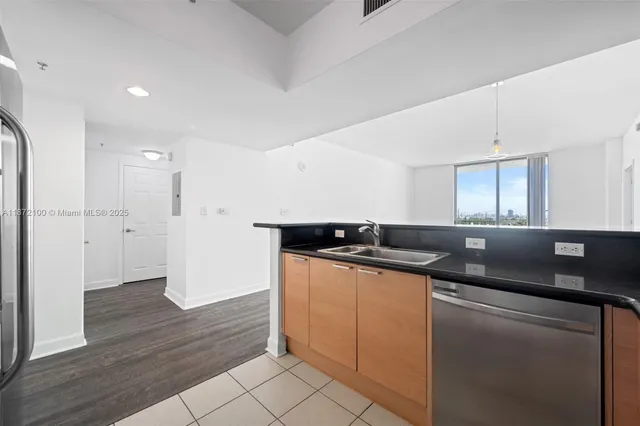 a kitchen with stainless steel appliances granite countertop a sink and a refrigerator