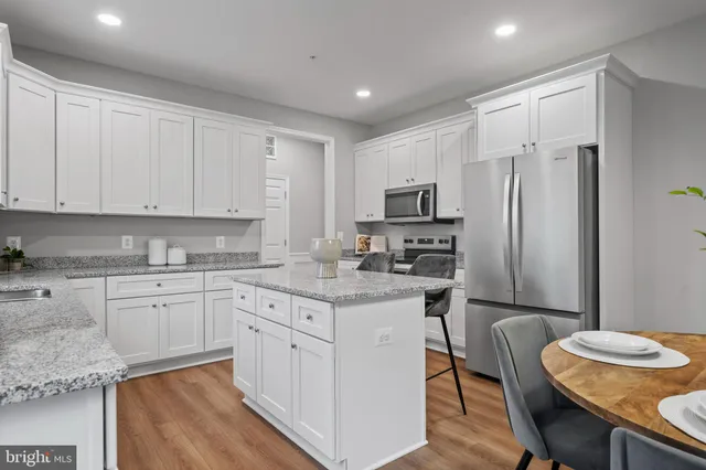 a kitchen with stainless steel appliances granite countertop a white cabinets and a refrigerator