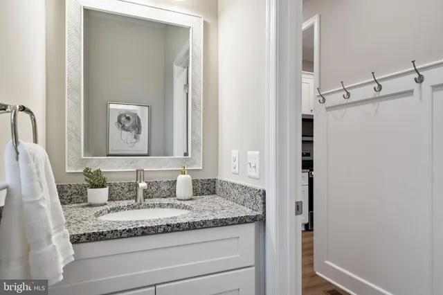 a bathroom with a granite countertop sink and a mirror