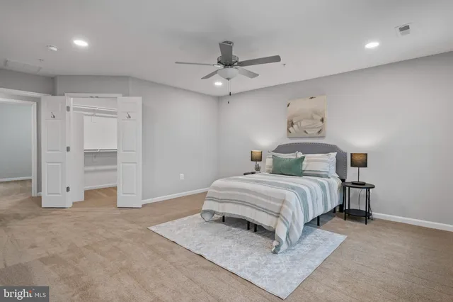 a spacious bedroom with a bed and a ceiling fan