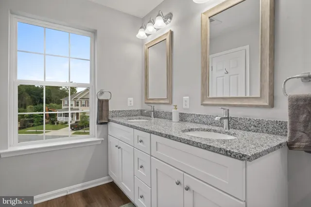 a bathroom with a granite countertop sink and a mirror