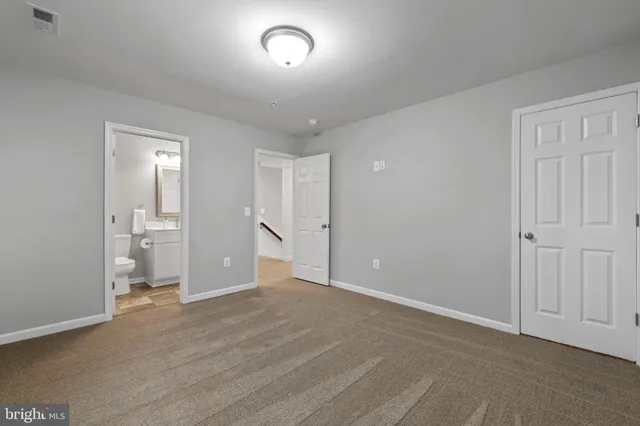 a view of an empty room and a kitchen