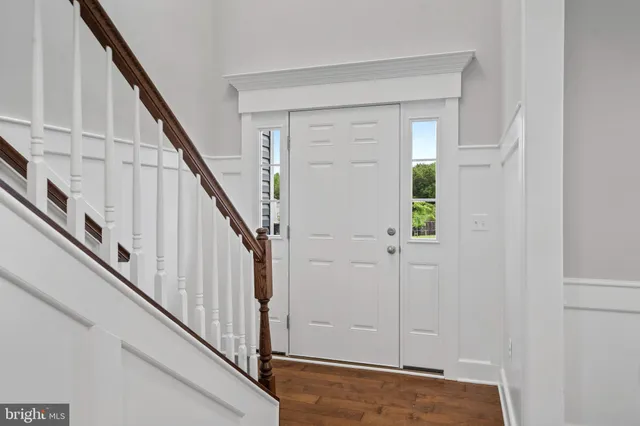 wooden floor with white walls and stairs