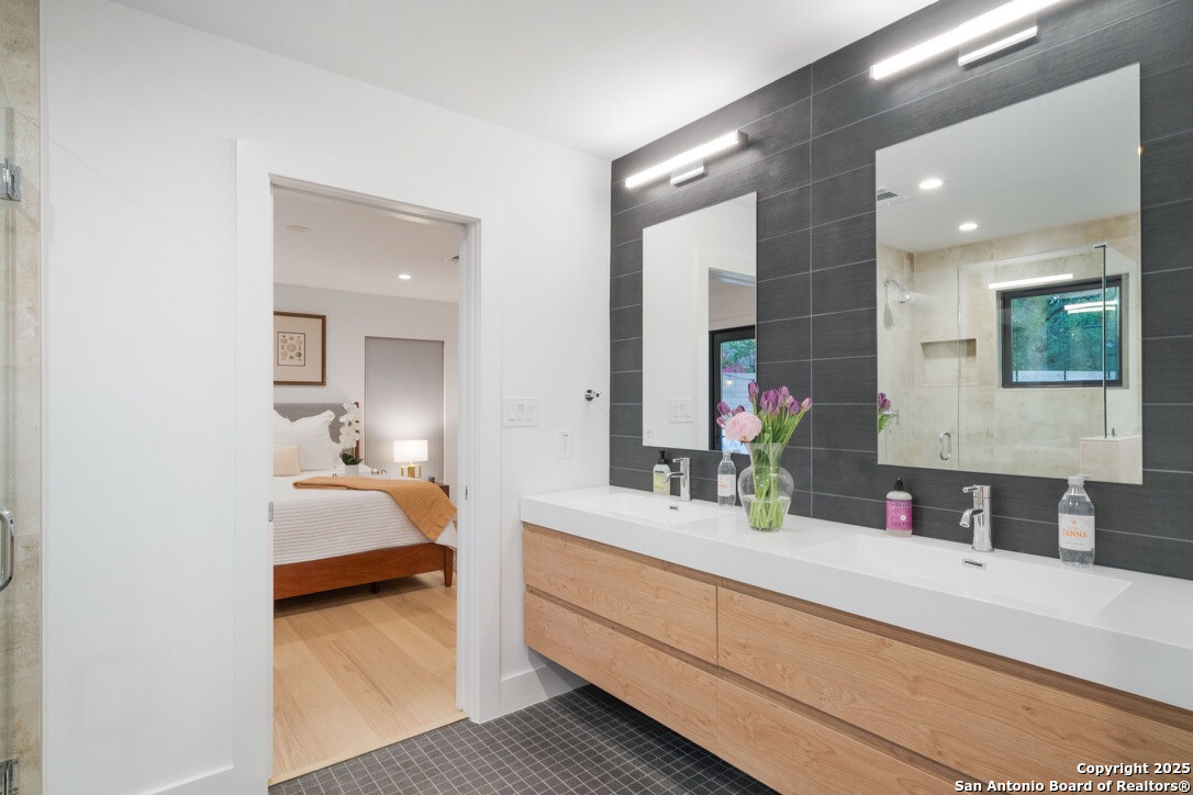 8900 Point W Drive Austin, TX 78759 - Photo 12 of 29 a en suite bathroom with a double vanity sink and mirror