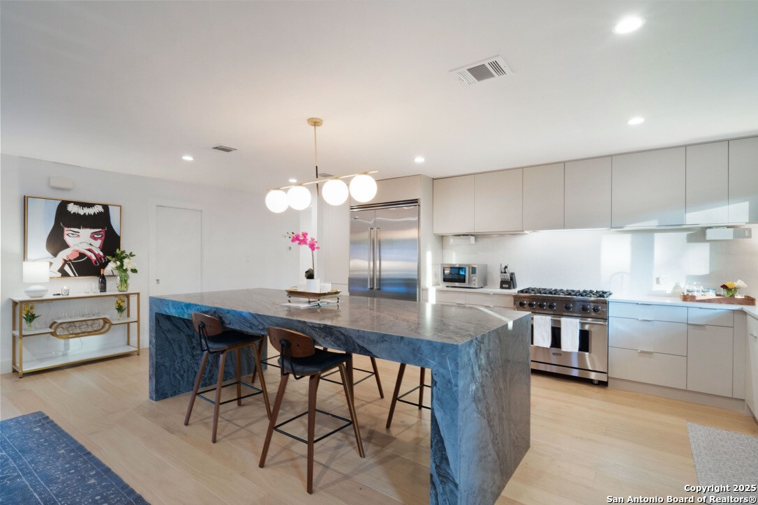 8900 Point W Drive Austin, TX 78759 - Photo 6 of 29 a kitchen with kitchen island a stove a table and chairs in it