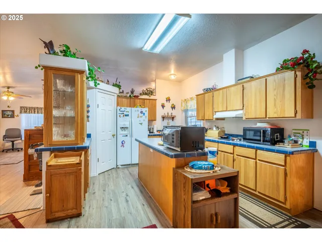 a kitchen with stainless steel appliances granite countertop a stove top oven a sink dishwasher and cabinets with wooden floor