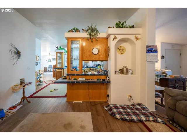 a living room with furniture and a dining table with wooden floor