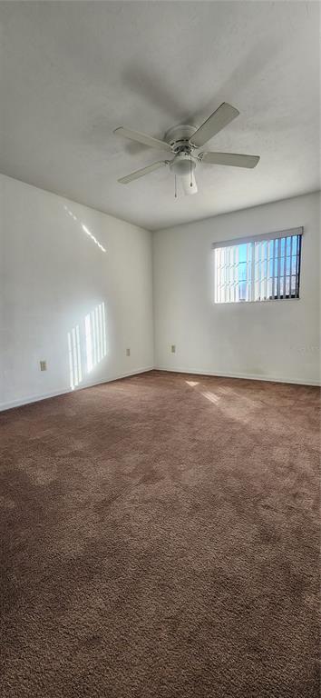 5734 Southwest 8th Place Gainesville, FL 32607 - Photo 12 of 18 an empty room with windows and ceiling fan