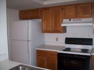 5734 Southwest 8th Place Gainesville, FL 32607 - Photo 4 of 10 a kitchen with a stove and a refrigerator